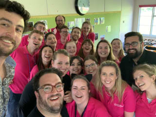Emily Varney in a friendly groupshot with other NYC staff wearing pink polo shirts
